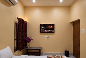 a room with a tv on the wall with a bed at Ratnadeep Palace - Near Kashi Vishwanath Temple & Ghats in Varanasi +10 photos