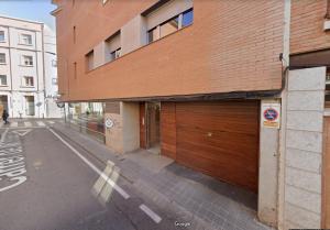 a building with two wooden garage doors on a street at M2 Apartament cèntric in Terrassa