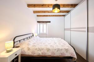 a bedroom with a bed and a white wall at Casa Gina in Grožnjan