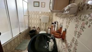 a bathroom with a black sink in the corner at Grandma Luísa's Corner in Verdelhos +34 photos