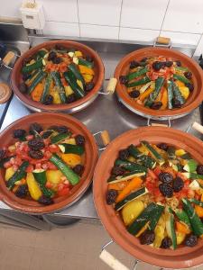 four pans filled with vegetables on a stove at Gite des Monges in Authon