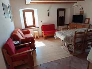 a living room with a table and a red chair at Giovanna Ribul Moro in Padola