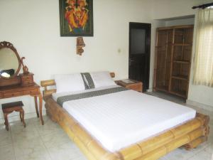 a bed in a room with a mirror and a table at Galang Kangin Bungalows 2 in Amed