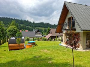 a house with a large yard next to a house at Willa Pod Wierzbami in Poronin