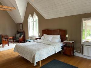 a bedroom with a bed and a table and two windows at Tornvillan in Mariehamn