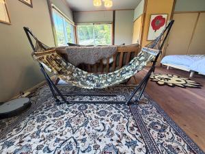 a hammock in a room with a rug at KUMANOYASAI BASE in Chikatsuyu in Chikatsuyu