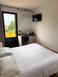 a bedroom with a white bed and a window at Agriturismo Terra Del Mare in Fossalòn