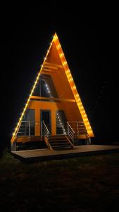 a house with a triangle roof with lights on it at Kolsai Satu in Saty