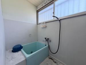 a bathroom with a bath tub and a window at KUMANOYASAI BASE in Chikatsuyu in Chikatsuyu