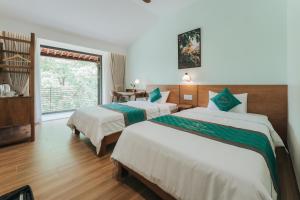 a hotel room with two beds and a window at November House in Thôn Kim Long (1)