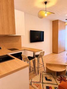 a kitchen and living room with a table and a tv at Rose Joséphine in Ajaccio