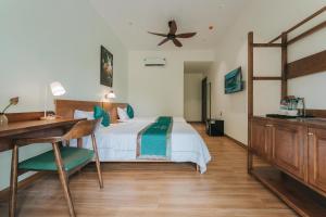a bedroom with a bed and a desk and a ceiling at November House in Thôn Kim Long (1)