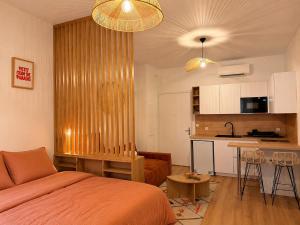 a bedroom with a bed and a kitchen with a table at Rose Joséphine in Ajaccio