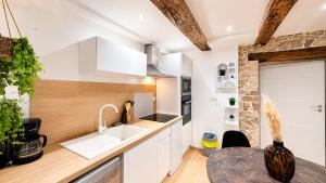 a kitchen with white cabinets and a sink at L'Adresse Mâconnaise Central - 2pers - Calme in Mâcon