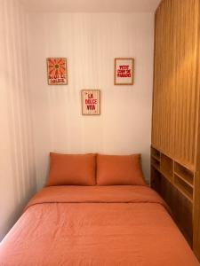a bed in a bedroom with three pictures on the wall at Rose Joséphine in Ajaccio