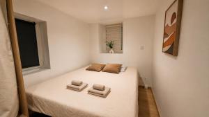 a small bedroom with a white bed with two pillows at L'Adresse Mâconnaise Central - 2pers - Calme in Mâcon