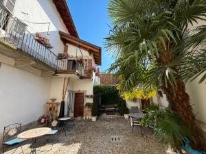 a courtyard with a palm tree and a building at Mansarde & Suite Maison 1706 Lago Orta in Borgomanero