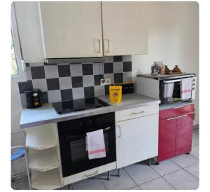 a kitchen with white cabinets and a black stove top oven at Pierre de lumiere in Toulouse