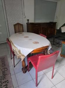 a table with four red chairs and a white table and chairs at Pierre de lumiere in Toulouse +2 photos