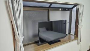 a flat screen tv in a window with curtains at 勝清居 大阪獨棟車庫民宿 千日前線新深江站2分一線直達 難波日本橋 全新裝修3LDk in Osaka
