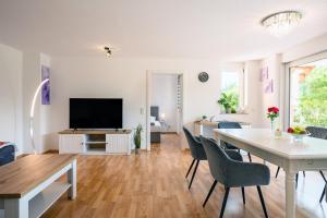a living room with a dining table and a television at Plätzchen im Grünen in Owingen