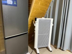 a heater next to a refrigerator in a room at Esal Rest Zone in Tong