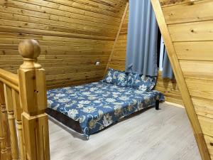 a small bed in a wooden room with a staircase at Esal Rest Zone in Tong