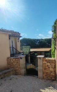 a gate to a house with a stone wall at Studio 263 in Suze-la-Rousse