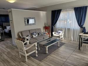 a living room with a couch and two chairs at Naomi's Sky Loft Little Falls in Roodepoort