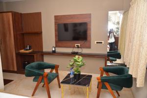 a living room with a table and chairs and a television at HOTEL THIRD EYE bY RAMANA TOWERS in Tiruvannāmalai +9 photos