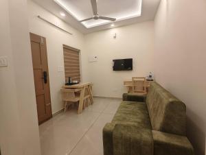 a living room with a couch and a flat screen tv at Ayra Inn in Cochin