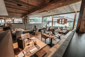 a dining room with tables and chairs and windows at Erlebnisort Gassenhof in Ridanna