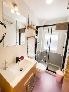 a bathroom with a sink and a toilet and a shower at Apartamento de 2 dormitorios en el centro de Burgos junto a la Catedral in Burgos +15 photos