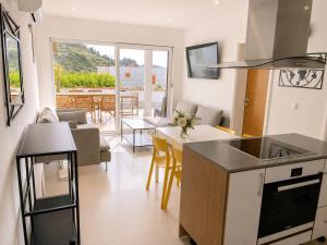 a kitchen and living room with a table and chairs at Lady A Apartment Jacuzzi Garden Outdoor Kitchen in Podglavica