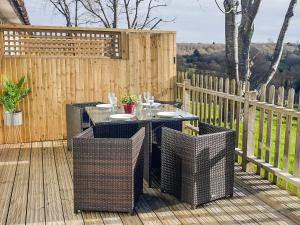 a patio with a table and chairs on a wooden deck at Ash Cottage in Uckfield
