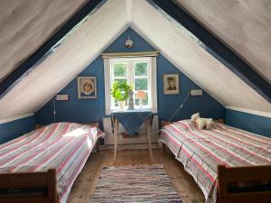 a attic bedroom with two beds and a window at Sjöberg's Cosy Cottage in Ljungby