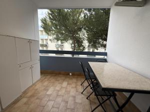 a room with a table and chairs and a window at Condominio Vera Cruz in Bibione