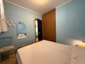 a bedroom with a bed and a chair and a mirror at Condominio Vera Cruz in Bibione +194 photos