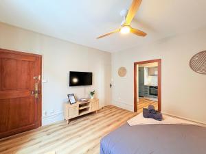 a bedroom with a bed and a flat screen tv at L'instant à Foix - Authentique & Chaleureux in Foix