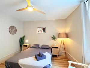a bedroom with a bed and a ceiling fan at L'instant à Foix - Authentique & Chaleureux in Foix