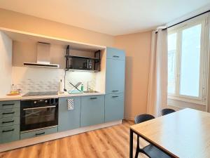 a kitchen with a blue refrigerator and a table at L'instant à Foix - Authentique & Chaleureux in Foix