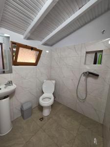 a bathroom with a toilet and a sink and a shower at Zoi's sea view in Himare