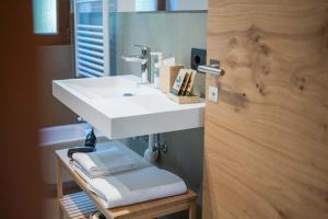 a bathroom with a white sink and a mirror at Alpen Suite Apartment in San Vigilio Di Marebbe +16 photos