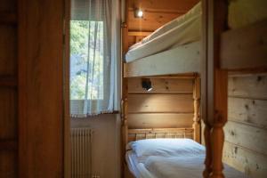 a bedroom with two bunk beds and a window at Alpen Suite Apartment in San Vigilio Di Marebbe