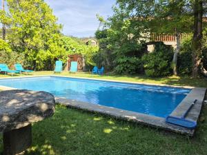a swimming pool in a yard with blue chairs at Villa Vetusta in Penso