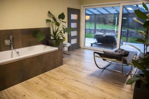 a bathroom with a tub and a chair and a tub and a tub at Bellalaens in Zemst