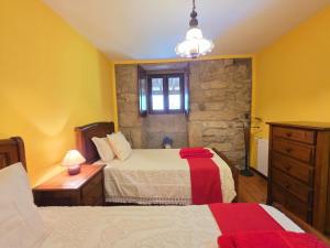 a bedroom with two beds and a stone wall at Villa Vetusta in Penso +32 photos