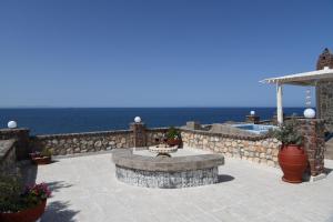a patio with a fountain and the ocean in the background at Starlight Luxury Seaside Villa & Suites in Imerovigli