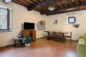 a living room with a table and a television at Casolare Sotto le Mura in Anghiari