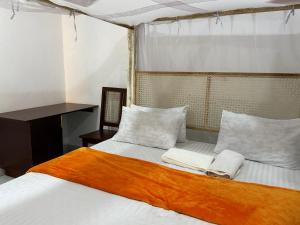 a bedroom with a bed with two towels on it at KK Homes in Diani Beach +62 photos